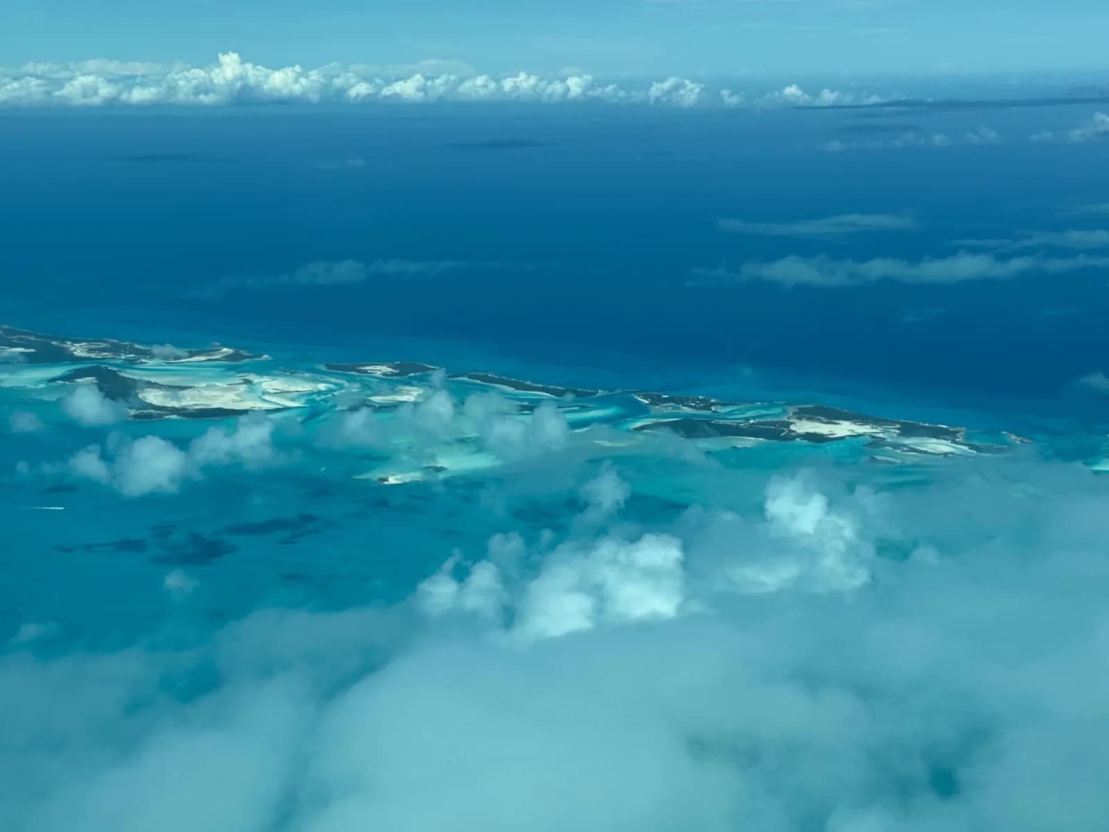 Die Inselkette der Exumas unter Wolken aus der Luft
