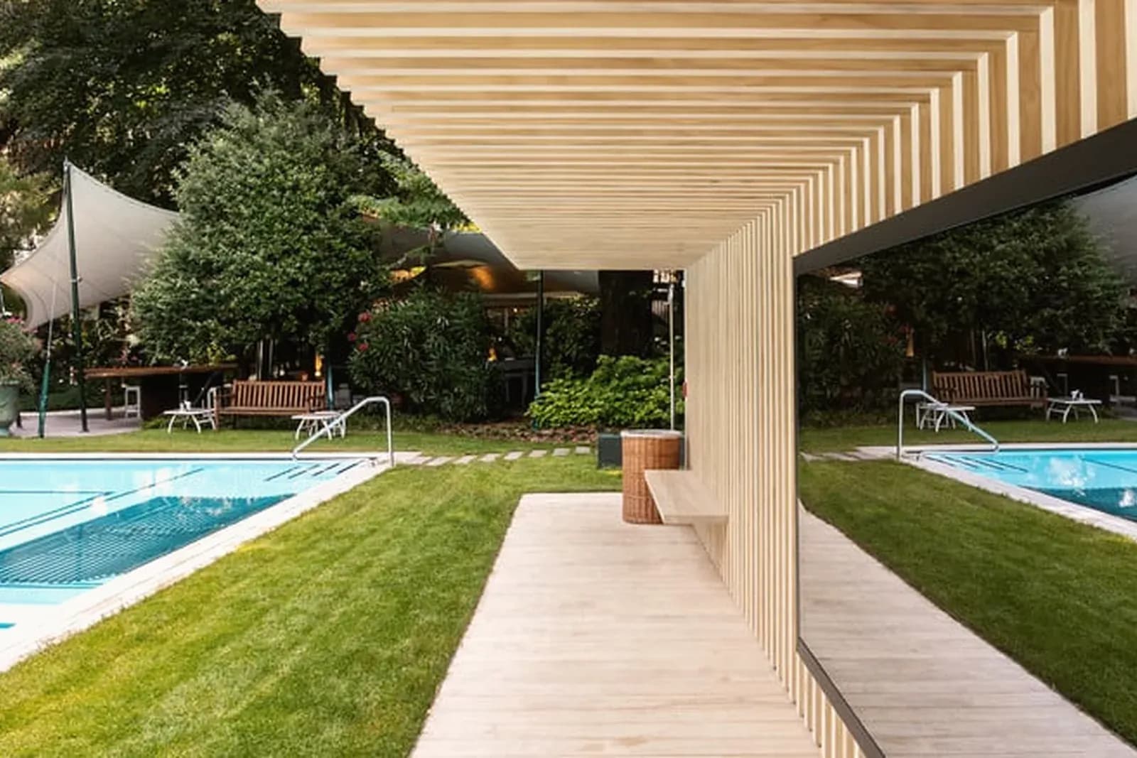 Parkhotel Laurin – Poolbereich mit Holzpergola und Liegewiese