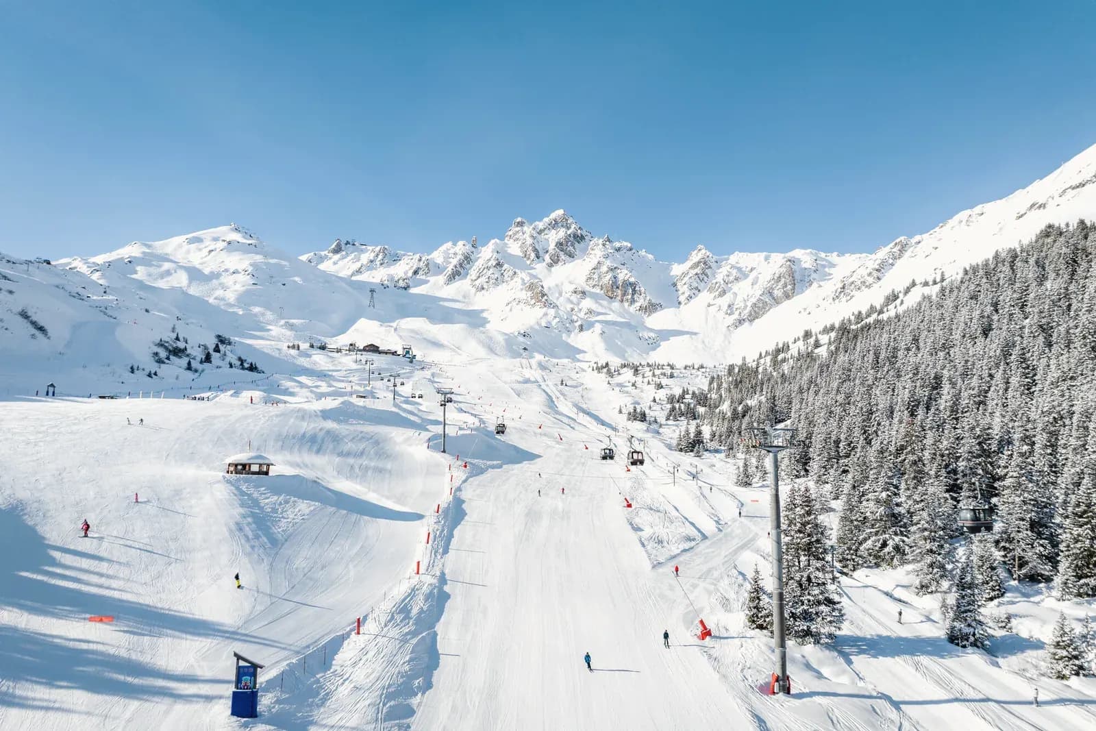 Breite Piste vor den Gipfeln der Trois Vallées
