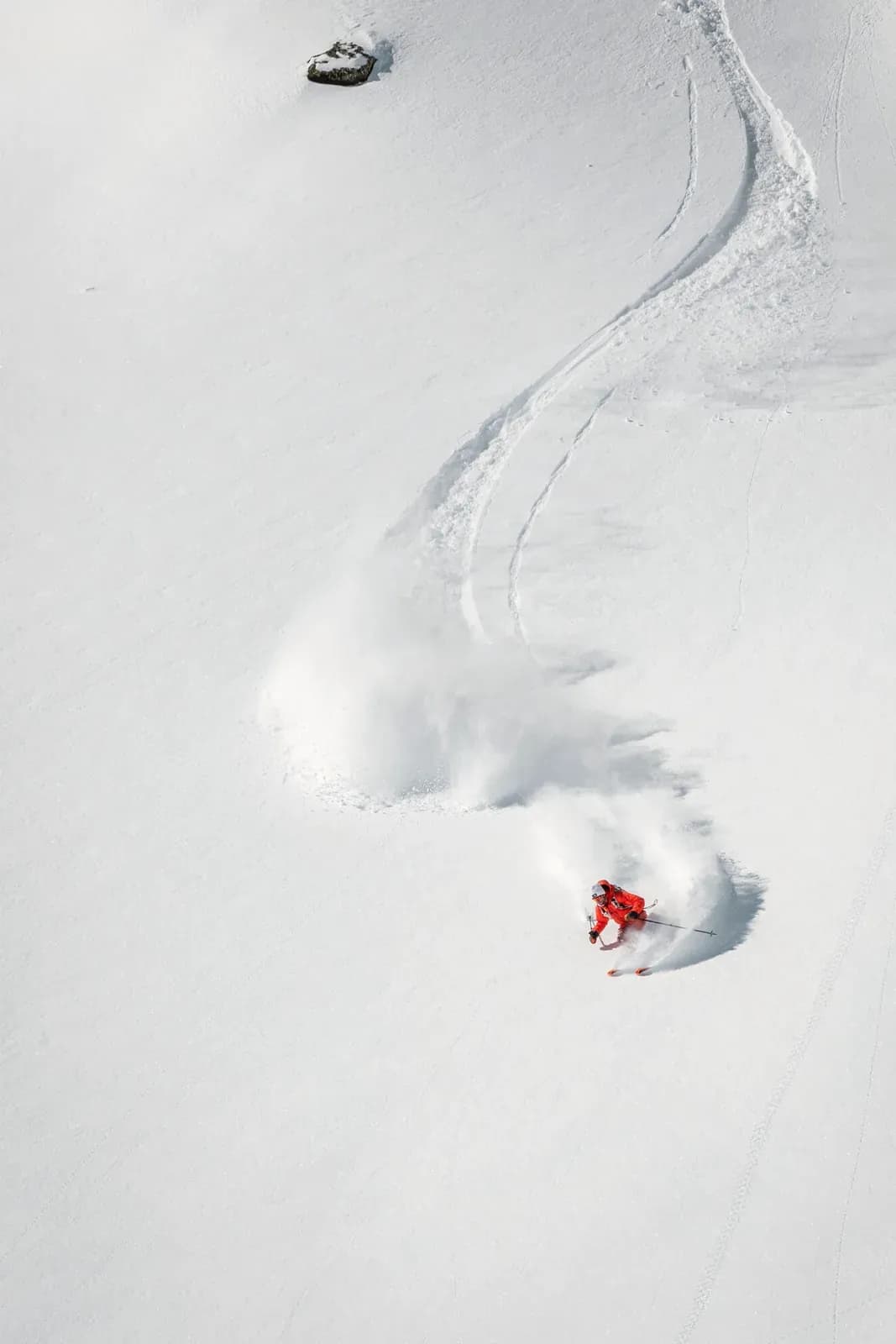 Einzelner Skifahrer zieht eine Spur durch unberührten Tiefschnee