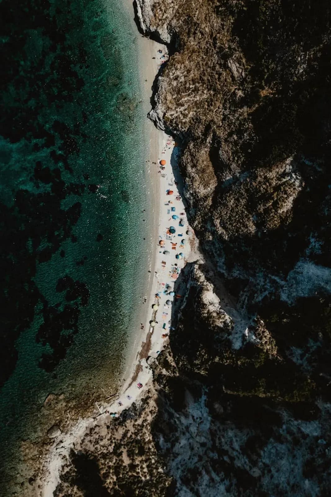 Schmaler Strand zwischen Felsen von oben
