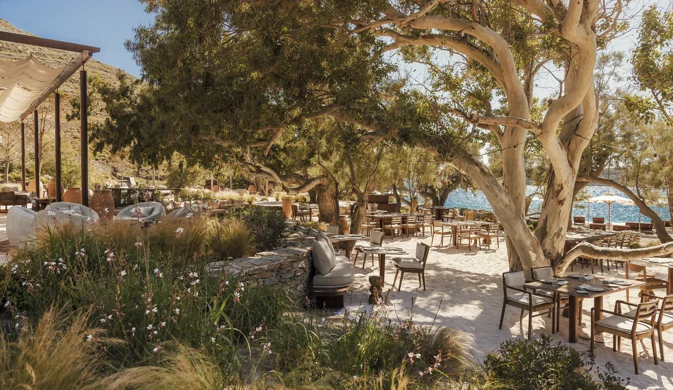 Bond Beach Club am Sandstrand in der Bucht von Vroskopos