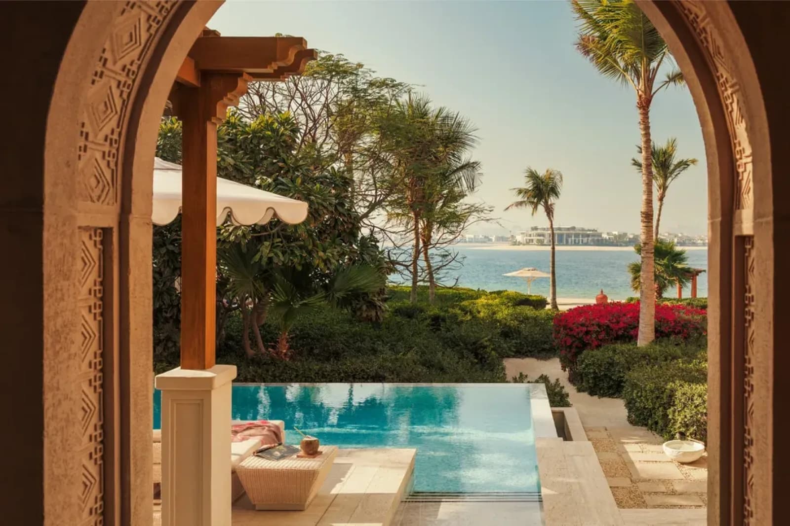 One&Only The Palm – Blick durch den Bogengang auf Pool und Meer