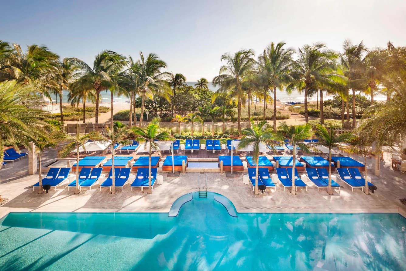 St. Regis Bal Harbour – Pool und Liegenterrasse, dahinter Palmen und der Privatstrand