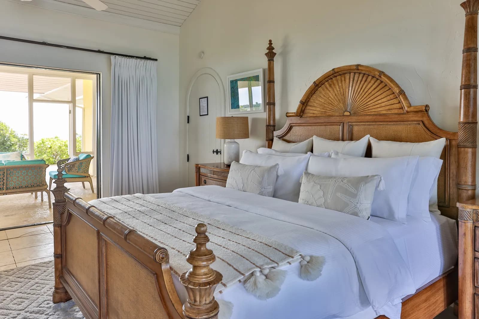 Villa Birdcage – Schlafzimmer mit geschnitztem Kopfteil und Zugang zur Terrasse
