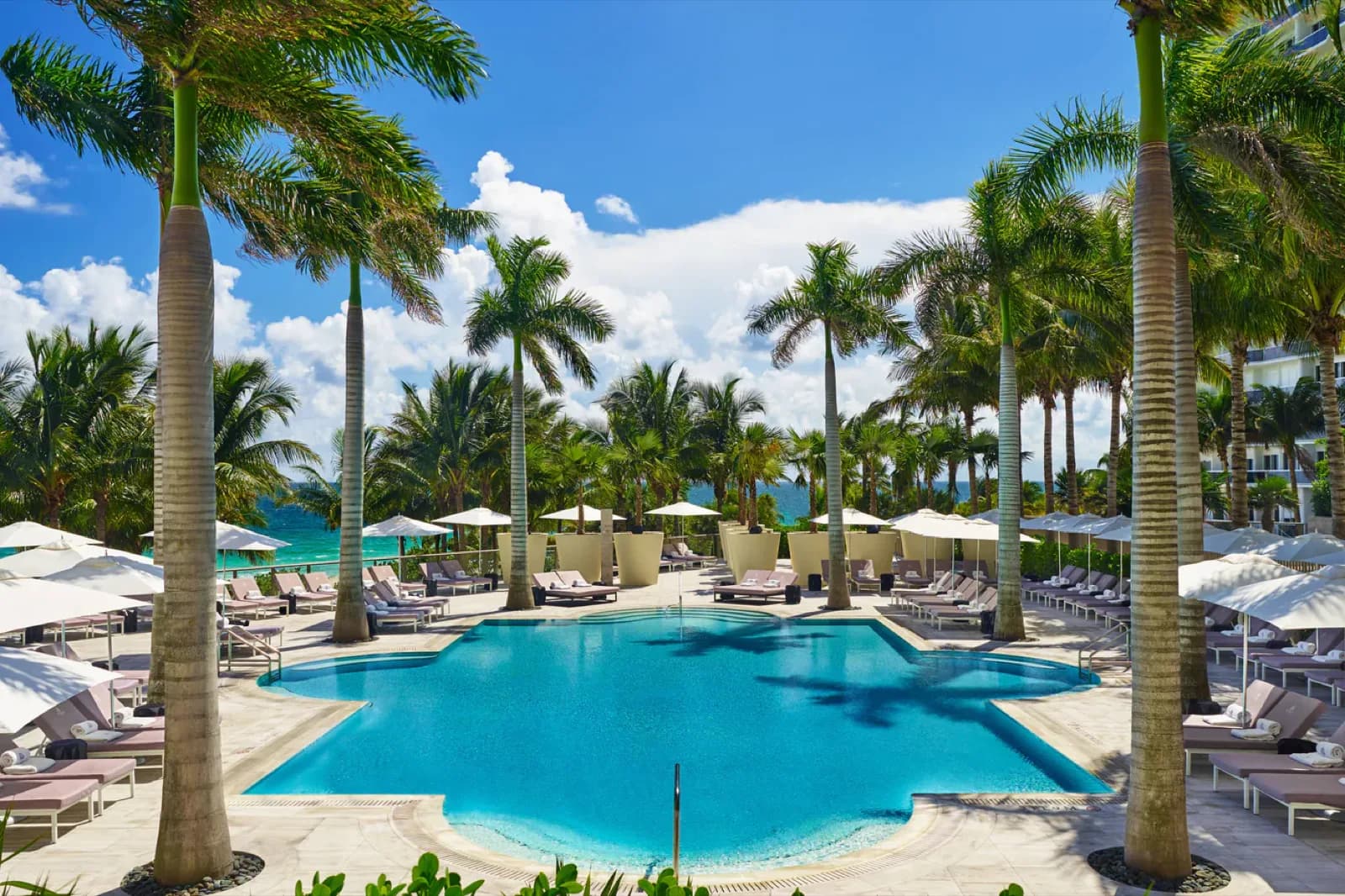 St. Regis Bal Harbour – großer Pool mit Palmen und Sonnenschirmen