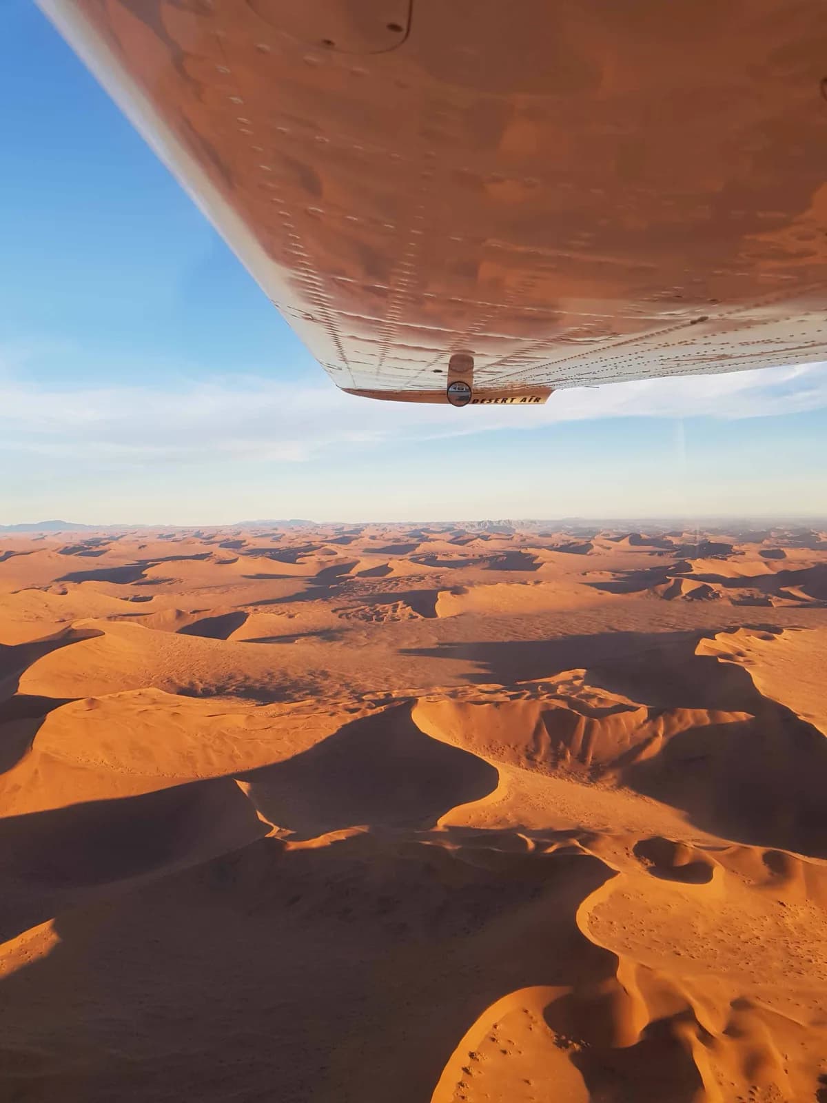 Blick über die Tragfläche auf das Dünenmeer der Namib