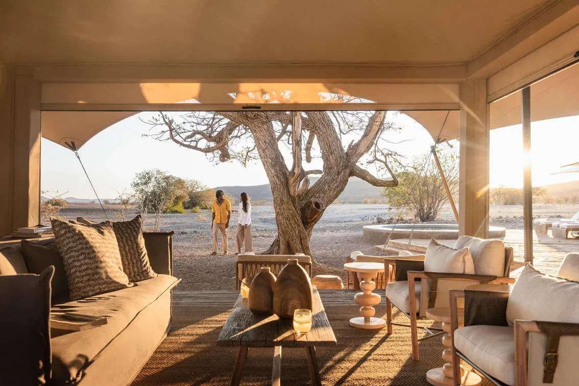 Offener Loungebereich des Desert Rhino Camp um einen Baum herum