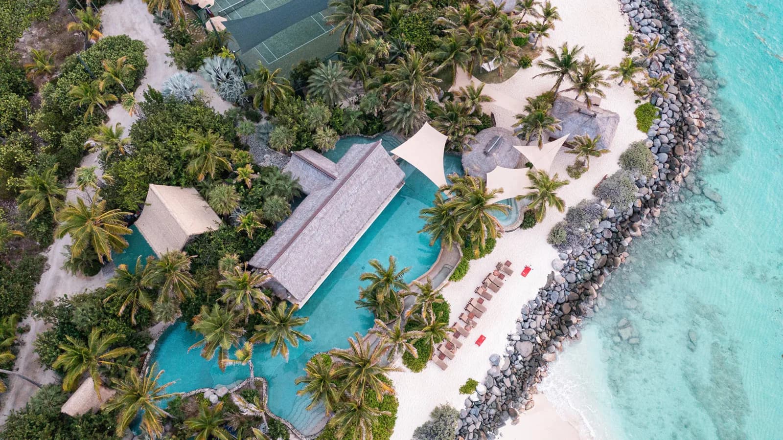 Pools und Palmen der Insel aus der Luft