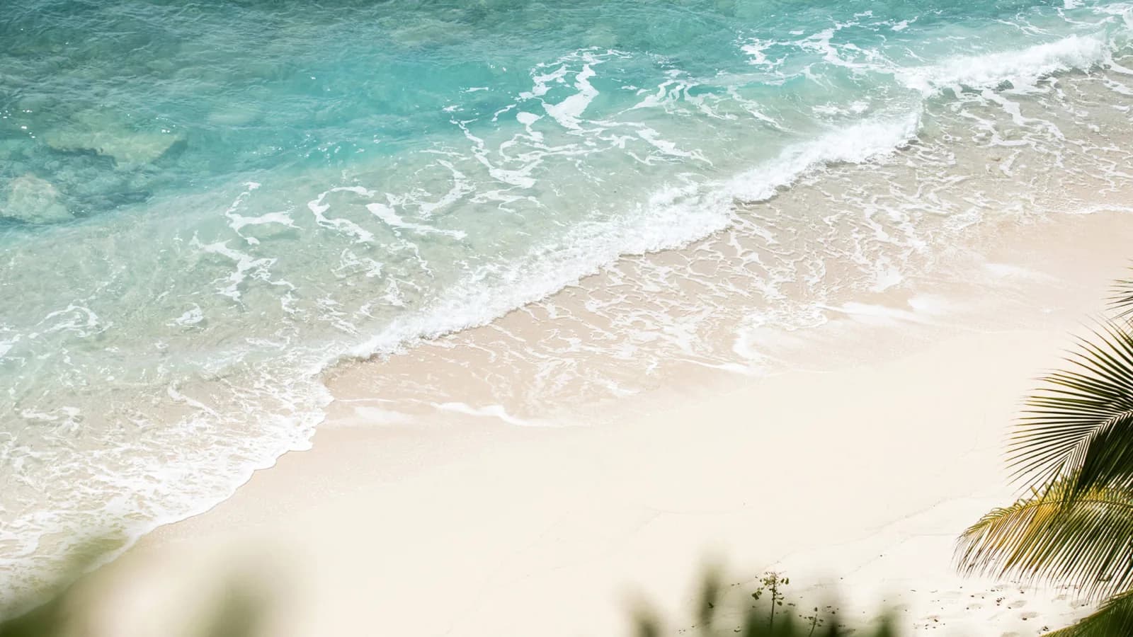 Brandung über dem weißen Sand von Necker Island