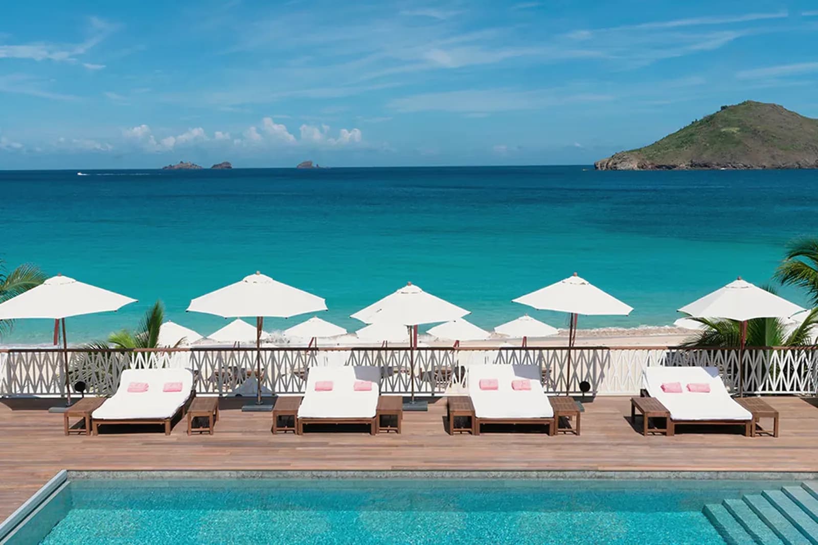 Cheval Blanc St. Barth – Liegen und Sonnenschirme am Pool über dem Strand