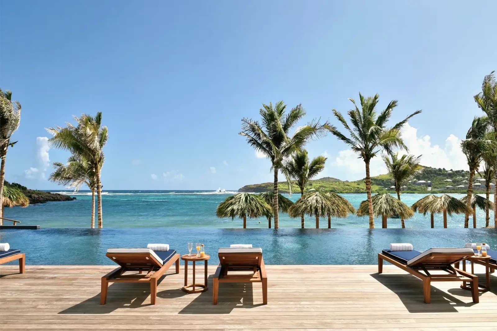 Infinity-Pool mit Liegen und Blick über die Lagune