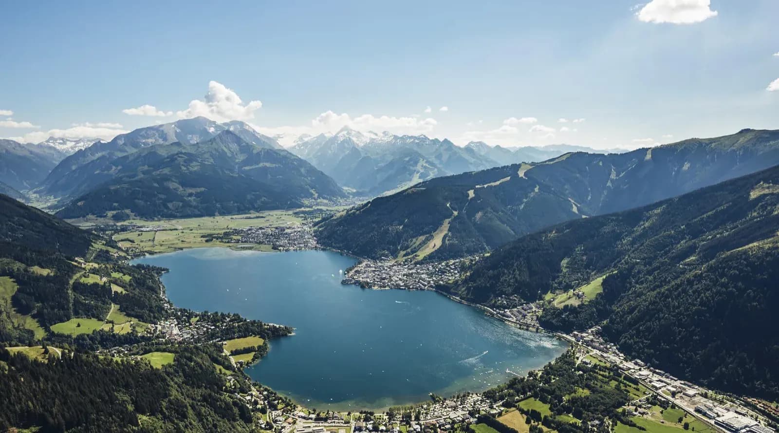Der Zeller See von oben, dahinter das Panorama der Hohen Tauern