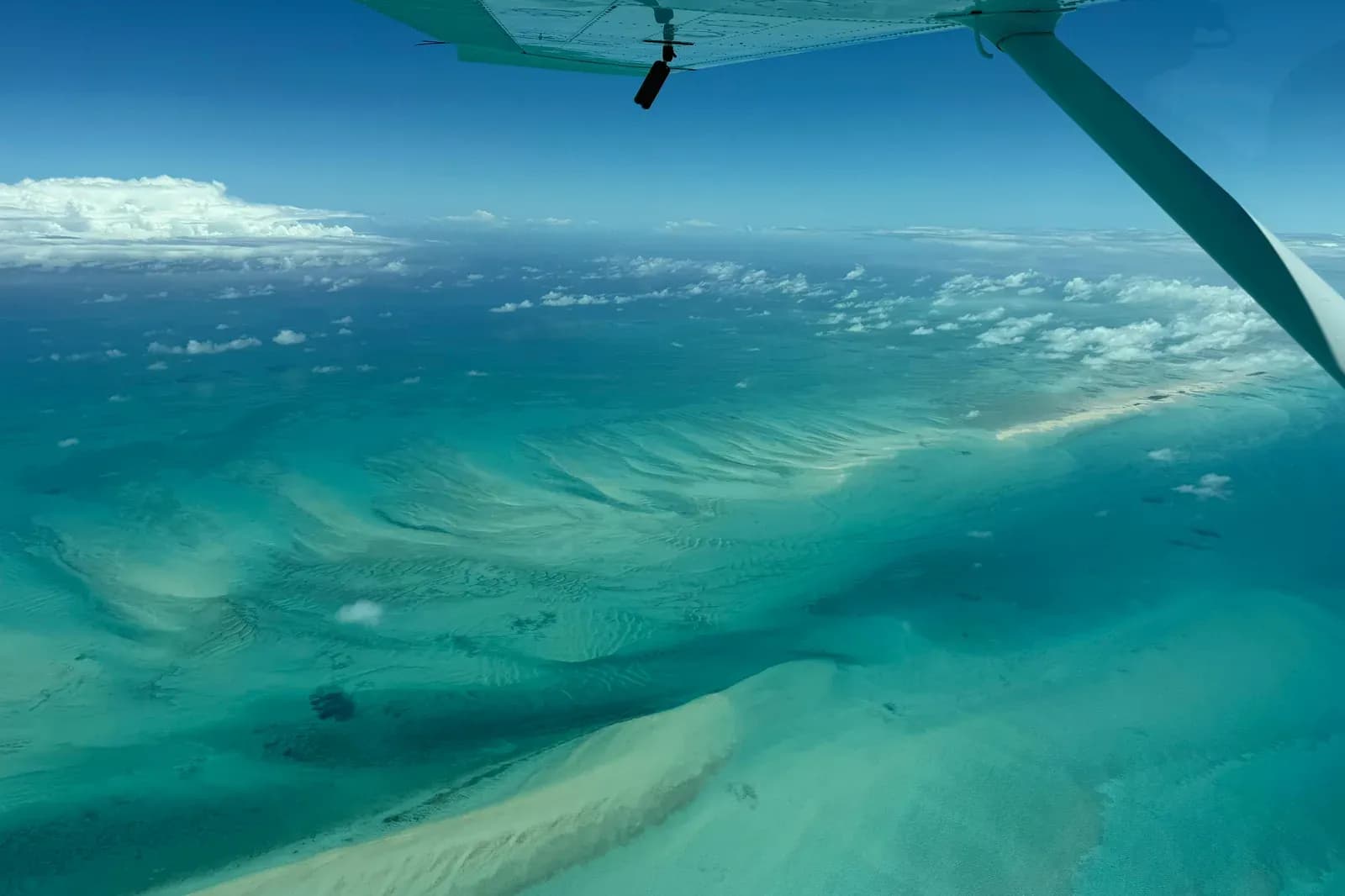 Blick über die Tragfläche der Cessna auf eine Sandbank